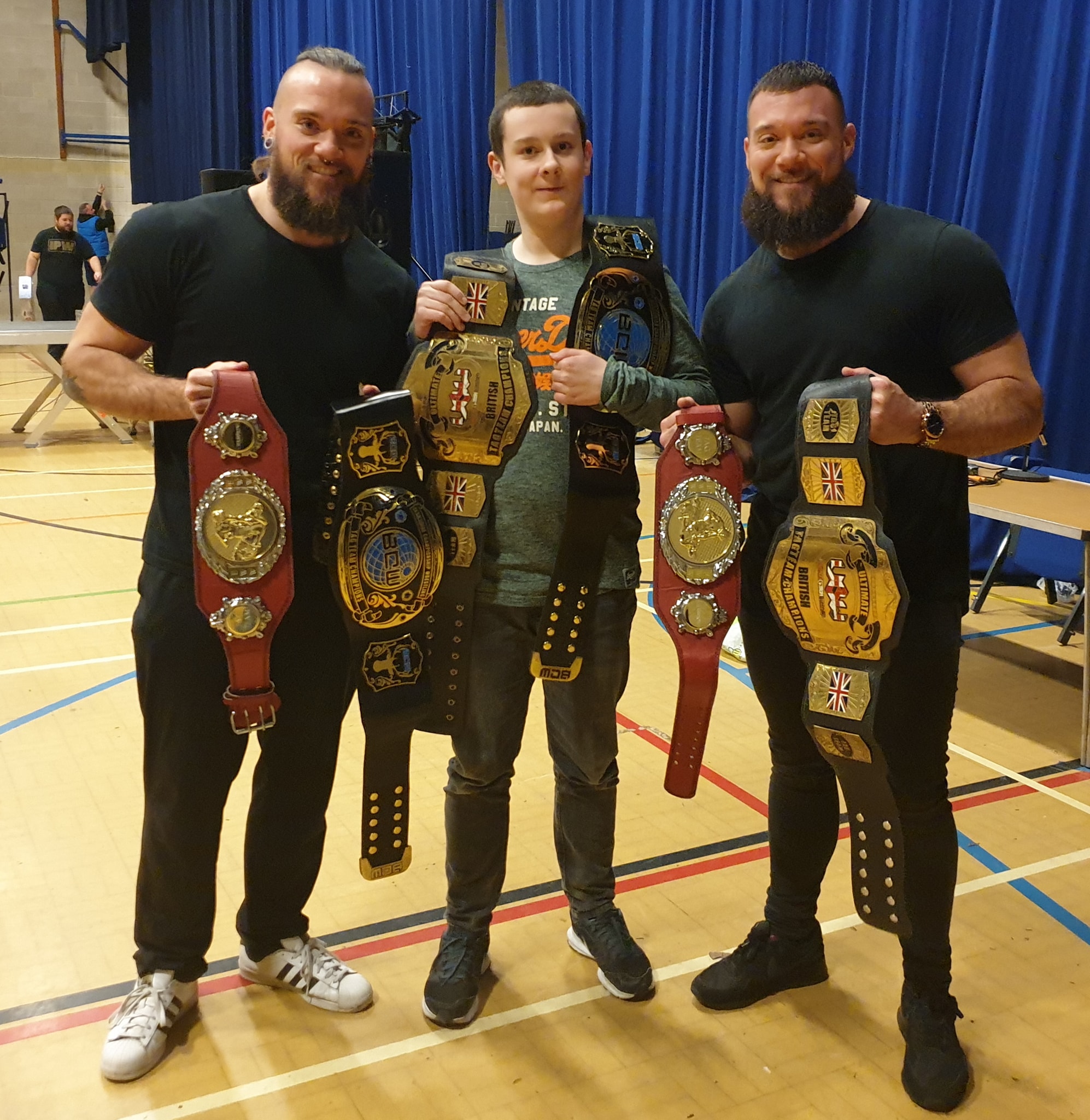 The Bone Brothers having picture taken with a fan and carrying 3 tag titles!